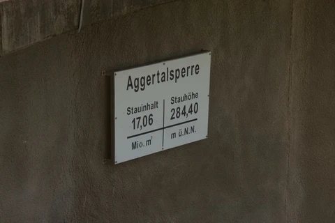 An einer Wand hängt eine weiße Tafel mit der Aufschrift "Aggertalsperre", "Stauinhalt 17,06 Mio. m³" und "Stauhöhe 284,40 m ü. NN"