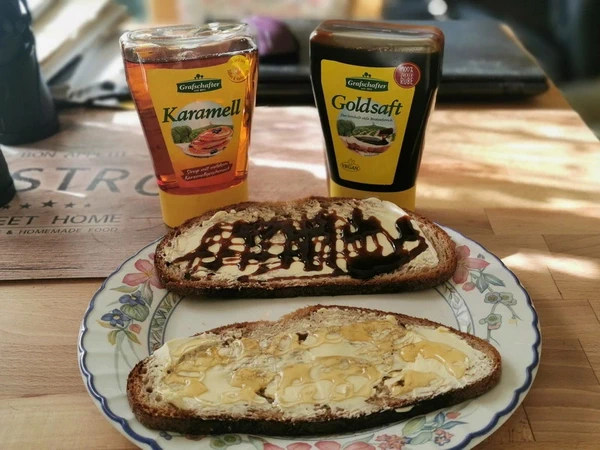 Rübenkraut und Karamell, in der Spenderflasche und auf der Schnitte Brot.