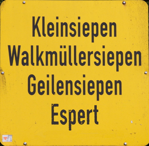 Ein gelbes Ortsschild in Radevormwald trägt in schwarzer Schrift die Ortsnamen "Kleinsiepen", "Walkmüllersiepen", "Geilensiepel" und "Espert"