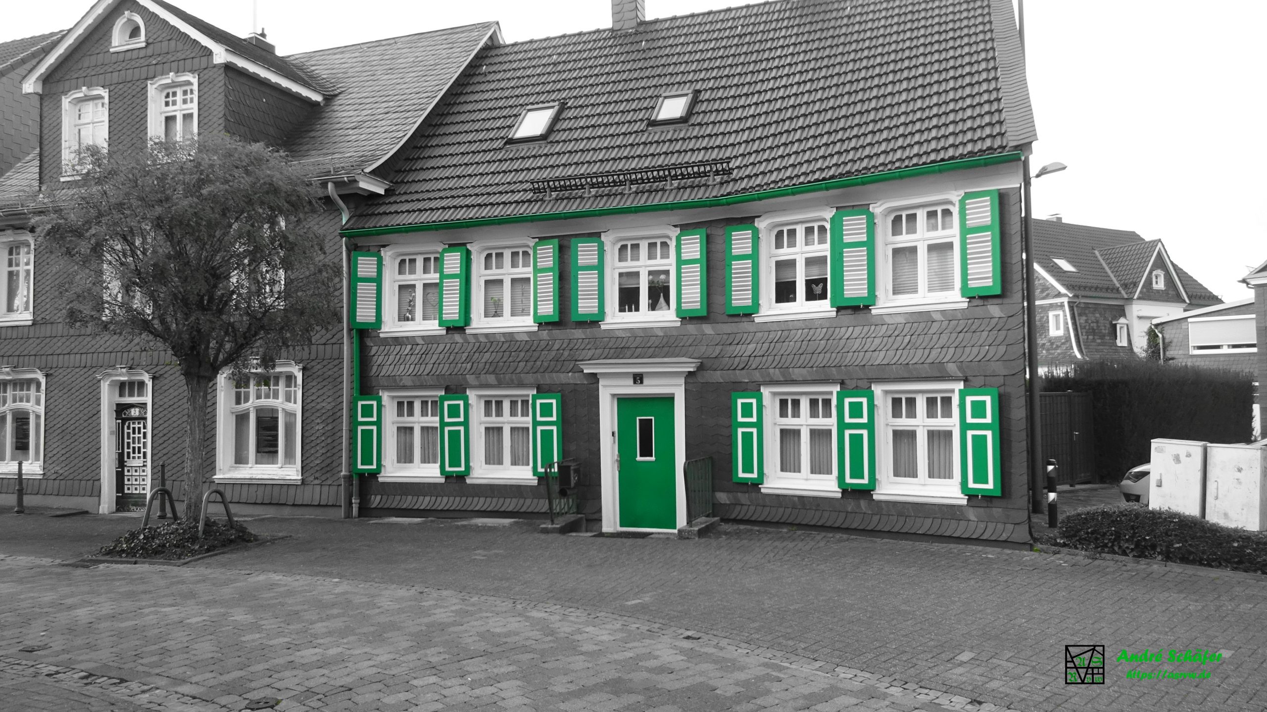 Haus Oststraße 5, Radevormwald, Bergisches Schieferhaus mit den typischen grünen Schlagläden, Schwarz-Weiß Bild mit grüner Teiltonung.