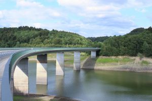 Auf mehreren, breiten Betonpfeilern führt die neue Kräwinkler Brücke in einer Rechtskurve über das Wasser der Wuppertalsperre.