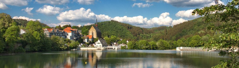 Auf der leicht gekräuselten Wasserfläche spiegeln sich Himmel, Wald, Beyenburger Altstadt und Kloster