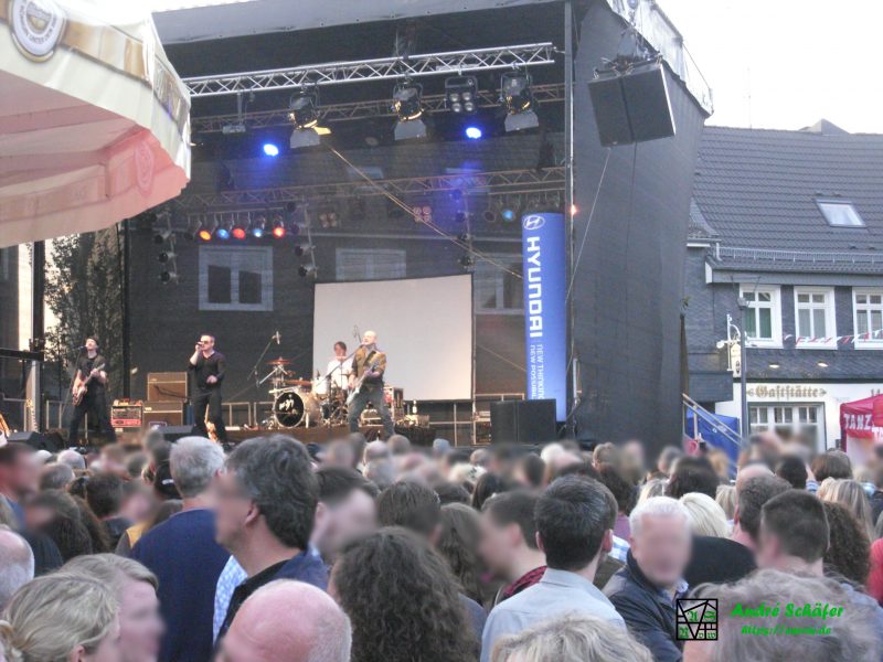 Auf einer Bühne auf dem Marktplatz rockt eine Cover-Band anlässlich der Feierlichkeiten zu 700 Jahre Radevormwald