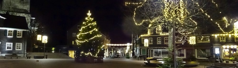 Radevormwalder Marktplatz bei Nacht. In der Mitte steht ein großer, beleuchteter Weihnachtsbaum