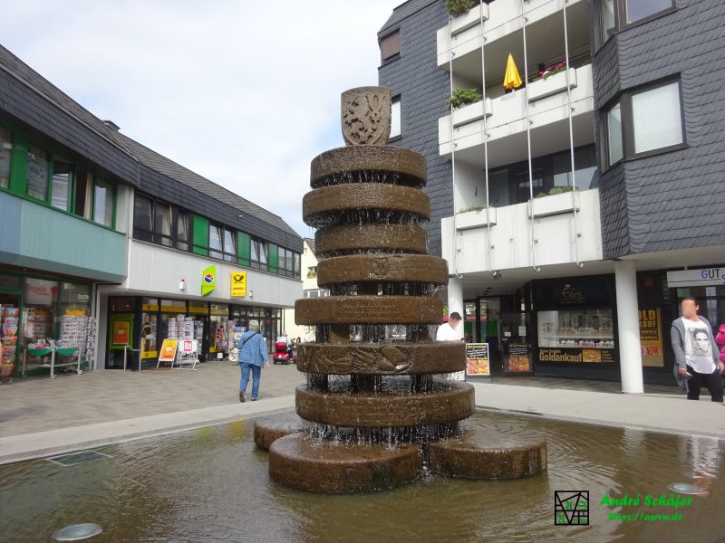 Ein kleiner Springbrunnen aus übereinander geschichteten, alten Mühlsteinen, in deren Seiten wichtige Ereignisse der Stadtgeschichte eingemeißelt sind