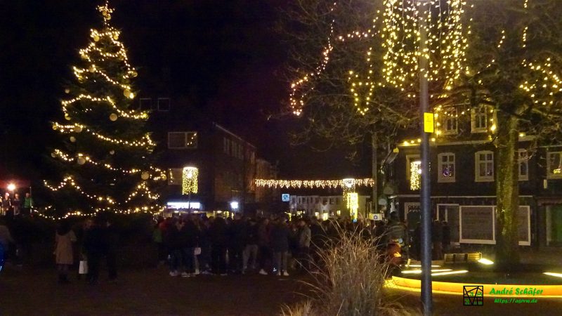 Zum nächtlichen Weihnachtssingen stehen die Menschen über den Marktplatz hinaus die Kaiserstraße entlang