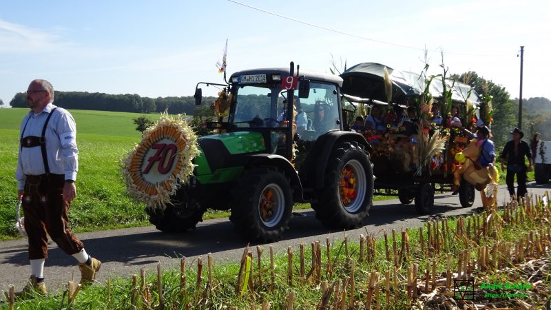 Ein geschmückter Traktor mit einem bunt geschmückten Anhänger